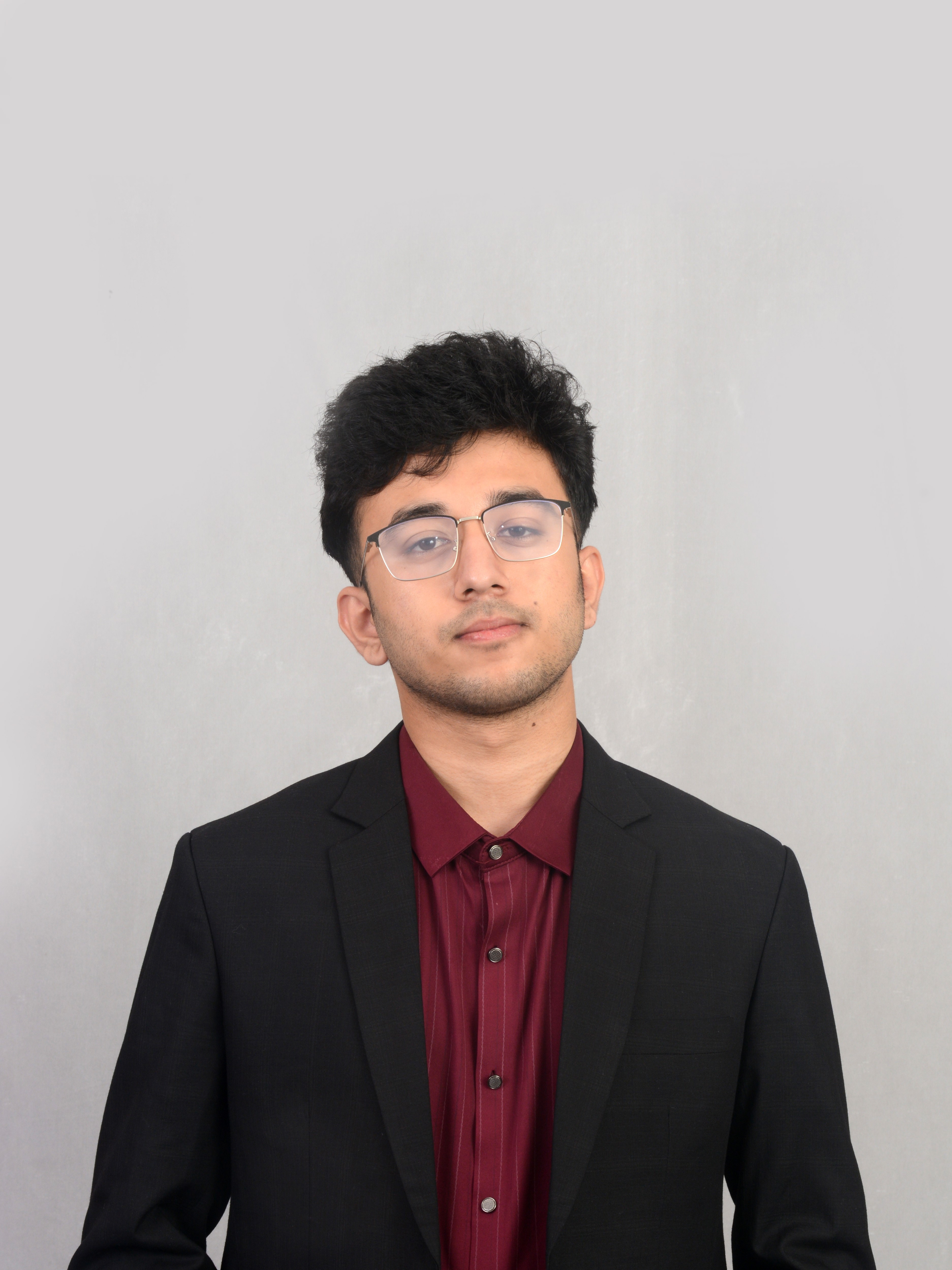 Prabesh Kharel in a black suit and burgundy shirt